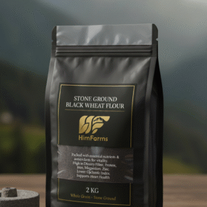 A close-up of dark, rich Himalayan Black Wheat flour in a rustic wooden bowl, with a small pile of black wheat grains beside it. The scene suggests natural, authentic produce.